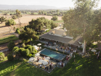 Drone shot of cokctail hour at the Roblar Farmhouse pool terrace Thumbnail